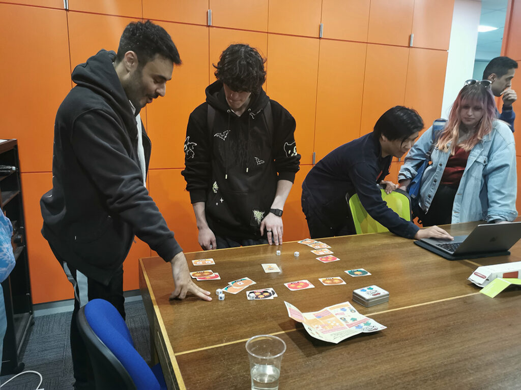 A photo of people playing the dice game at WIP Night.