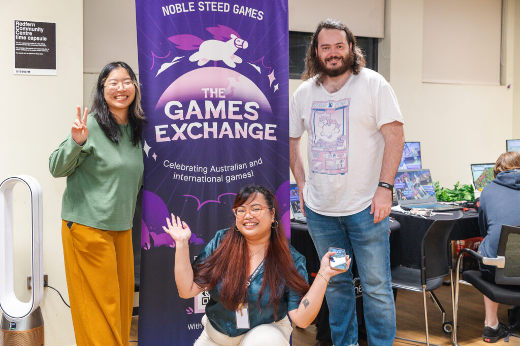 A group photo of the Noble Steed Games Team in front of the Games Exchange Banner.